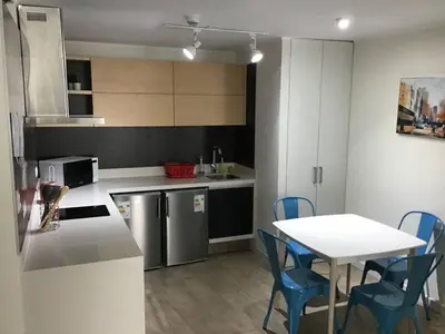 a kitchen with a table and a table and chairs at Moderno departamento Miraflorino con aire acondicionado in Lima