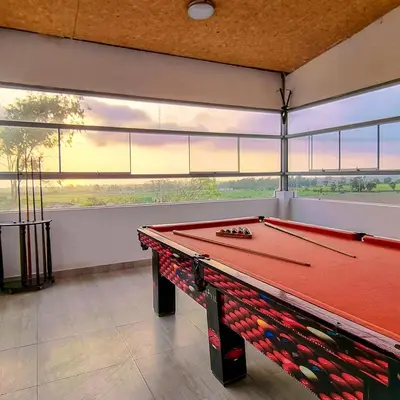 a red pool table in a room with windows at Apart Hotel El Paraíso de Barranca in Barranca