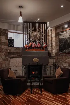 a living room with two couches and a fireplace at Hotel Arcangel in Cusco