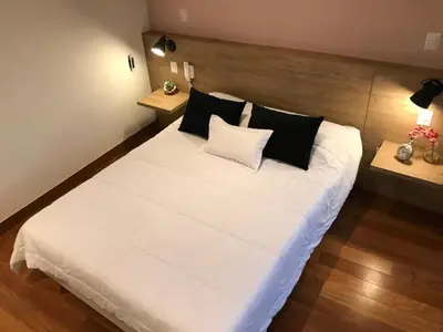 a bedroom with a large white bed with black pillows at MLA apartments - Buenos Aires in Lima
