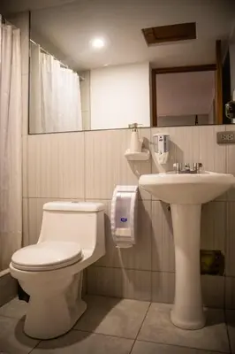 a bathroom with a toilet and a sink at Home Garden Hotel in Cusco