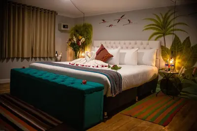 a bedroom with a large bed with a blue ottoman at Home Garden Hotel in Cusco