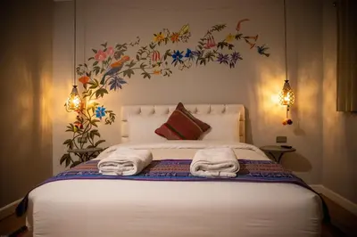a bedroom with a bed with towels on it at Home Garden Hotel in Cusco