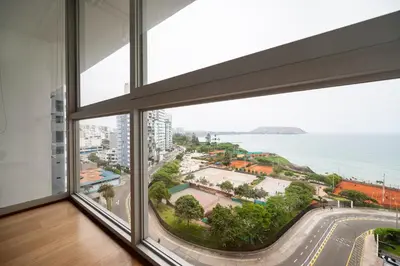 an empty room with a large window looking out at the ocean at InkaHuset Miraflores Oceanfront in Lima