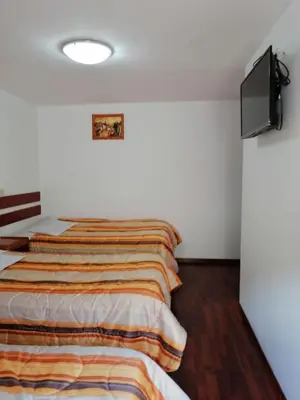 a bedroom with a bed and a flat screen tv at La Estación San Pedro in Cusco
