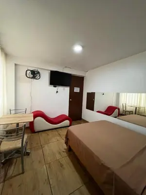 a bedroom with a bed and a desk and a tv at Hospedaje Senegal cerca al aeropuerto in Lima