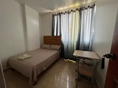 a small bedroom with a bed and a table at Hospedaje Senegal cerca al aeropuerto in Lima