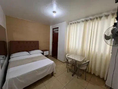 a bedroom with a bed and a desk and a window at Hospedaje Senegal cerca al aeropuerto in Lima