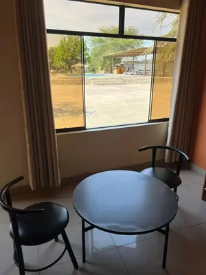 a room with two chairs and a table and a window at Hospedaje La Huega in Ica
