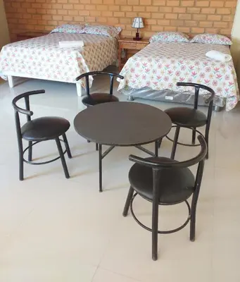 a room with a table and chairs and a bed at Hospedaje La Huega in Ica