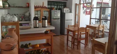 a kitchen with a refrigerator and a table and chairs at Casa Inka B&B in Ollantaytambo