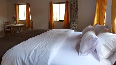 a bed with white sheets and pillows in a bedroom at Casa Inka B&B in Ollantaytambo