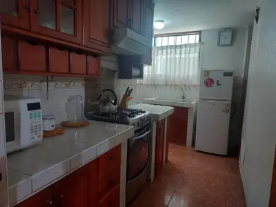 a small kitchen with a stove and a refrigerator at Mandalas Cusco in Cusco