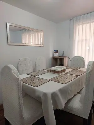 a dining room table with white chairs and a white table and chairsuggest at Pawllu Inqa Lodge in Cusco