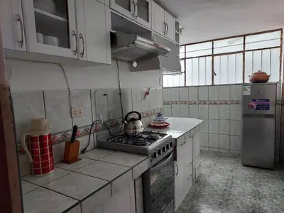 a kitchen with a stove and a refrigerator at Pawllu Inqa Lodge in Cusco