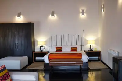 a bedroom with a large bed with orange pillows at Tocuyeros Boutique Hotel in Cusco