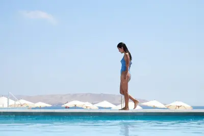 a woman walking on the edge of a swimming pool at Casa Andina Select Paracas in Paracas