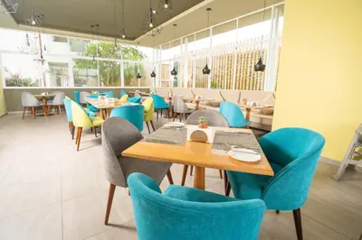 a dining room with blue chairs and tables at Casa Andina Select Paracas in Paracas