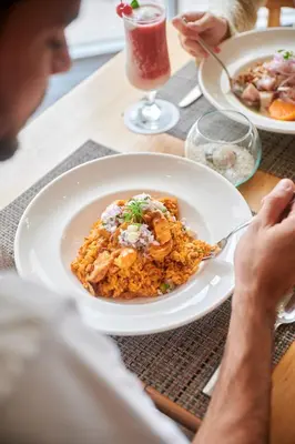a person sitting at a table with a plate of food at Casa Andina Select Paracas in Paracas