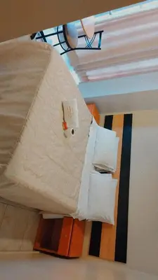 a room with a bed with white sheets and pillows at Hostal Parisuite in Lima