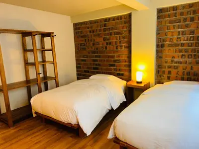 a bedroom with two beds and a brick wall at 1911 in Machu Picchu
