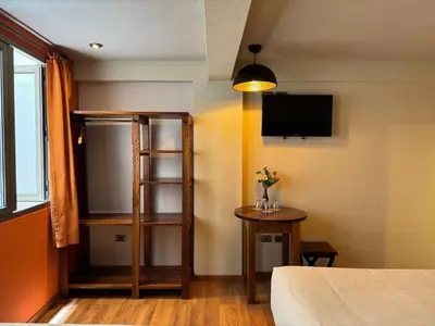 a room with a bed and a tv on the wall at 1911 in Machu Picchu