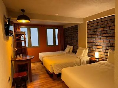 a room with two beds and a table and two windows at 1911 in Machu Picchu