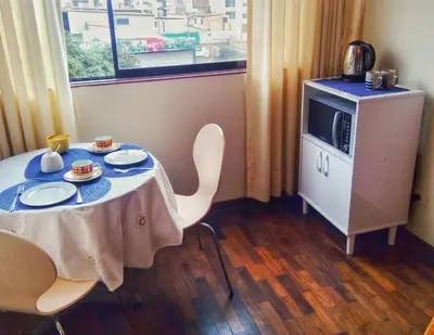 a room with a table with chairs and a tv at Amplia habitación con baño in Lima