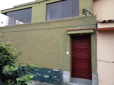 a red door on the side of a building at Sucesac in Lima