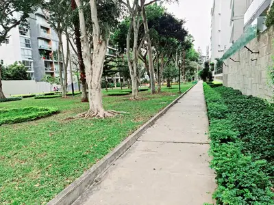 a sidewalk in a park with trees and a building at Miraflores Dpto 2 dorm. espaciosos 4 huéspedes 90m2 in Lima