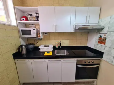 a kitchen with white cabinets and a sink and a microwave at Miraflores Dpto 2 dorm. espaciosos 4 huéspedes 90m2 in Lima