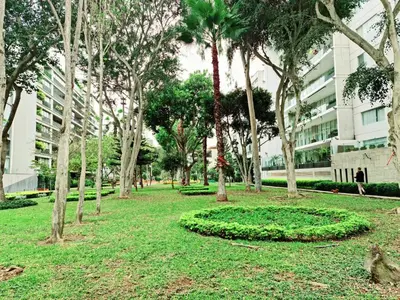 a park with palm trees and a building at Miraflores Dpto 2 dorm. espaciosos 4 huéspedes 90m2 in Lima