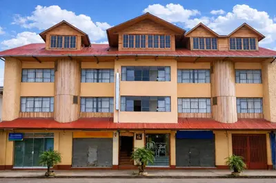 an orange building with a red roof at Hostal Arias in Oxapampa