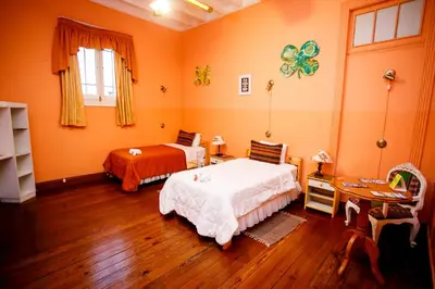 a bedroom with two beds and a table and a desk at Lima Wari Hotel Boutique in Lima