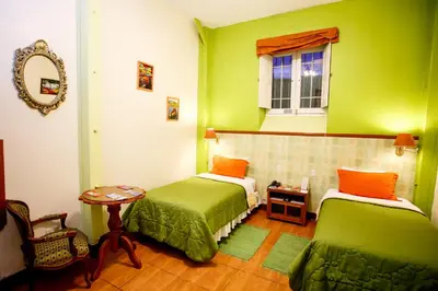 a green room with two beds and a window at Lima Wari Hotel Boutique in Lima