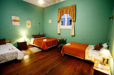 a green room with two beds and a window at Lima Wari Hotel Boutique in Lima