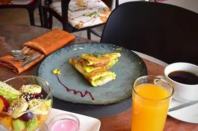 a plate of food on a table with orange juice at Wifala Harmony Hotel in Urubamba