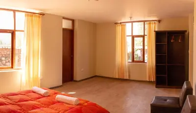 a bedroom with a bed and two windows at Allin Illary Eco Hospedaje in Urubamba