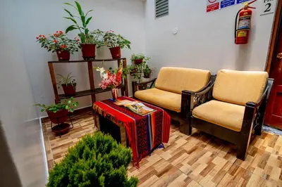 two chairs and a table in a room with plants at Hotel Machupicchu Inn in Machu Picchu