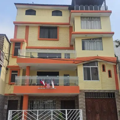 a tall building with two chairs on a balcony at Hostal Turístico El Cajamarquez in Lima