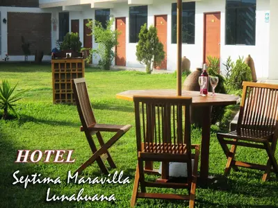a table with two chairs and a table with a bottle of wine at Hotel Septima Maravilla Lunahuana in Lunahuaná
