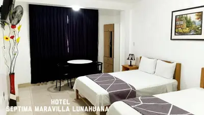 a hotel room with two beds and a table at Hotel Septima Maravilla Lunahuana in Lunahuaná