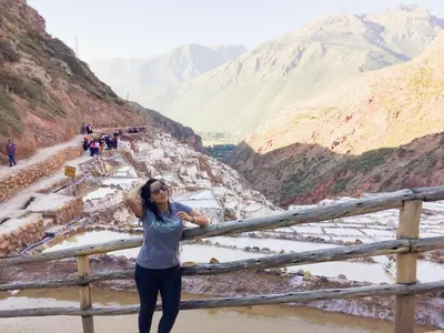 a woman standing next to a fence overlooking a canyon at Casa Patacalle in Ollantaytambo