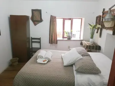 a bedroom with a bed with two towels on it at Casa Patacalle in Ollantaytambo
