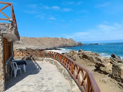 a wooden walkway leading to a beach with the ocean at Hotel Puerto Inka in Chala