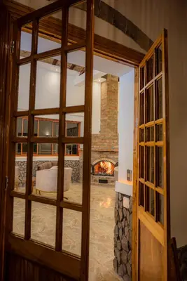an open door to a living room with a fireplace at Llamita Hotel-Huancayo in Huancayo