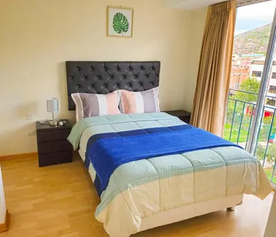 a bedroom with a large bed with a large window at Fiflos Apartament in Cusco