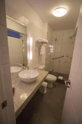a bathroom with two toilets and a sink and a shower at Tierra Viva Miraflores Larco in Lima