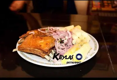 a plate of food with meat and vegetables on a table at Keylas Hotel in Ica