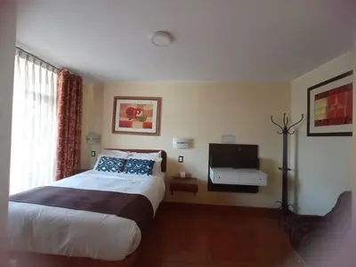a hotel room with a bed and a television at CasaHotel Centro - Huancayo in Huancayo